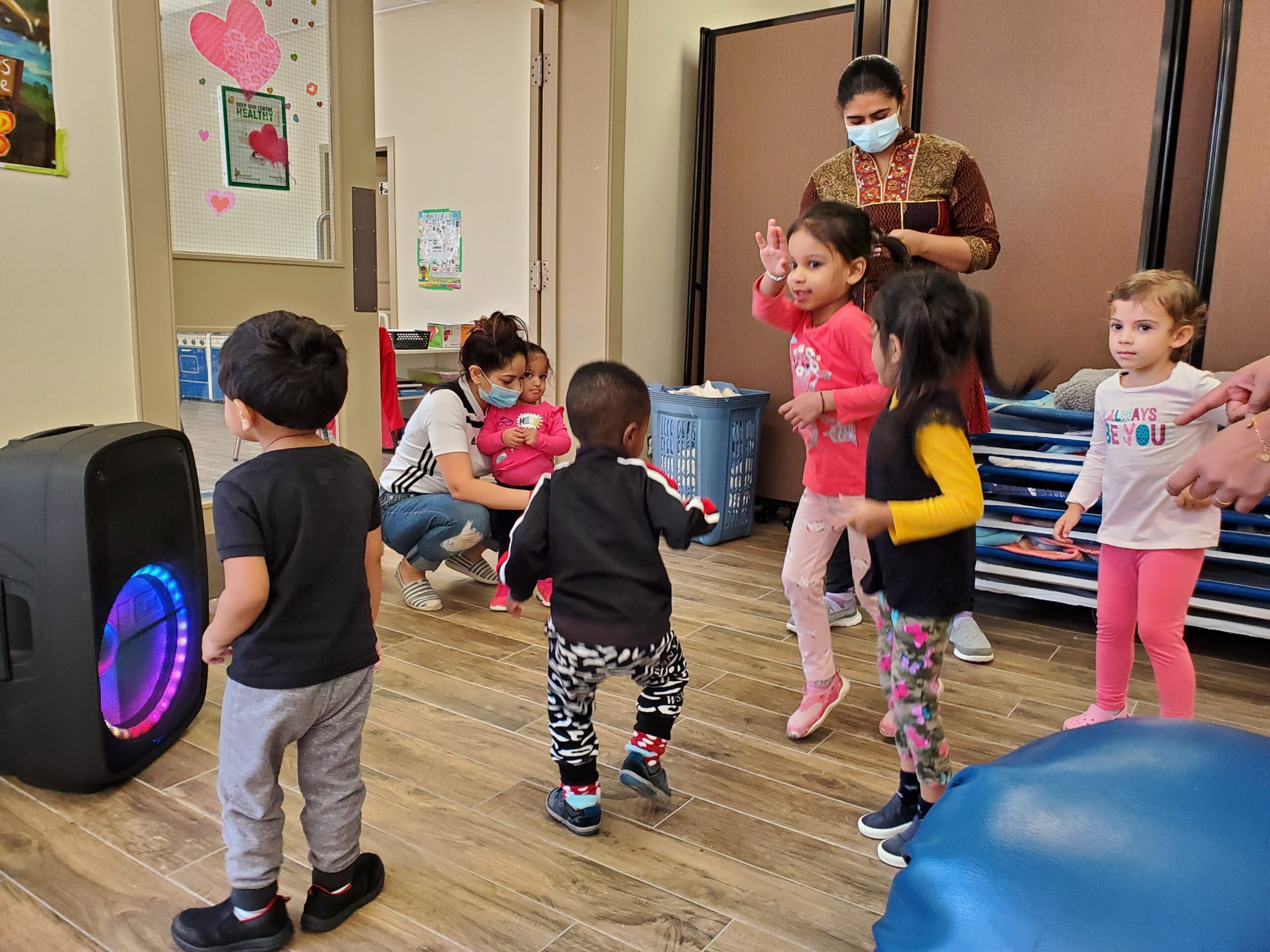 Children dancing together to music in the daycare room
