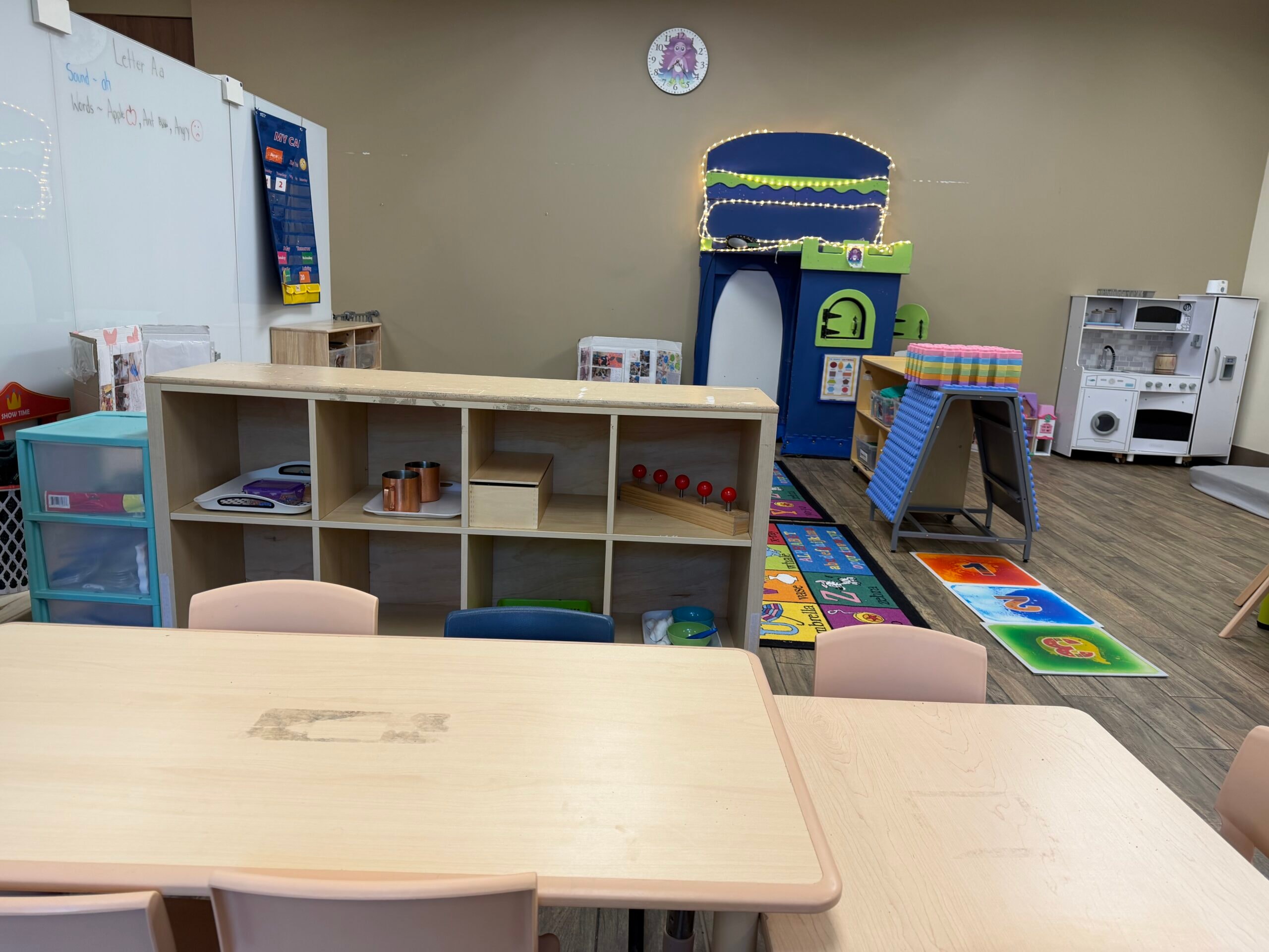 Preschool classroom with tables, chairs, and learning materials