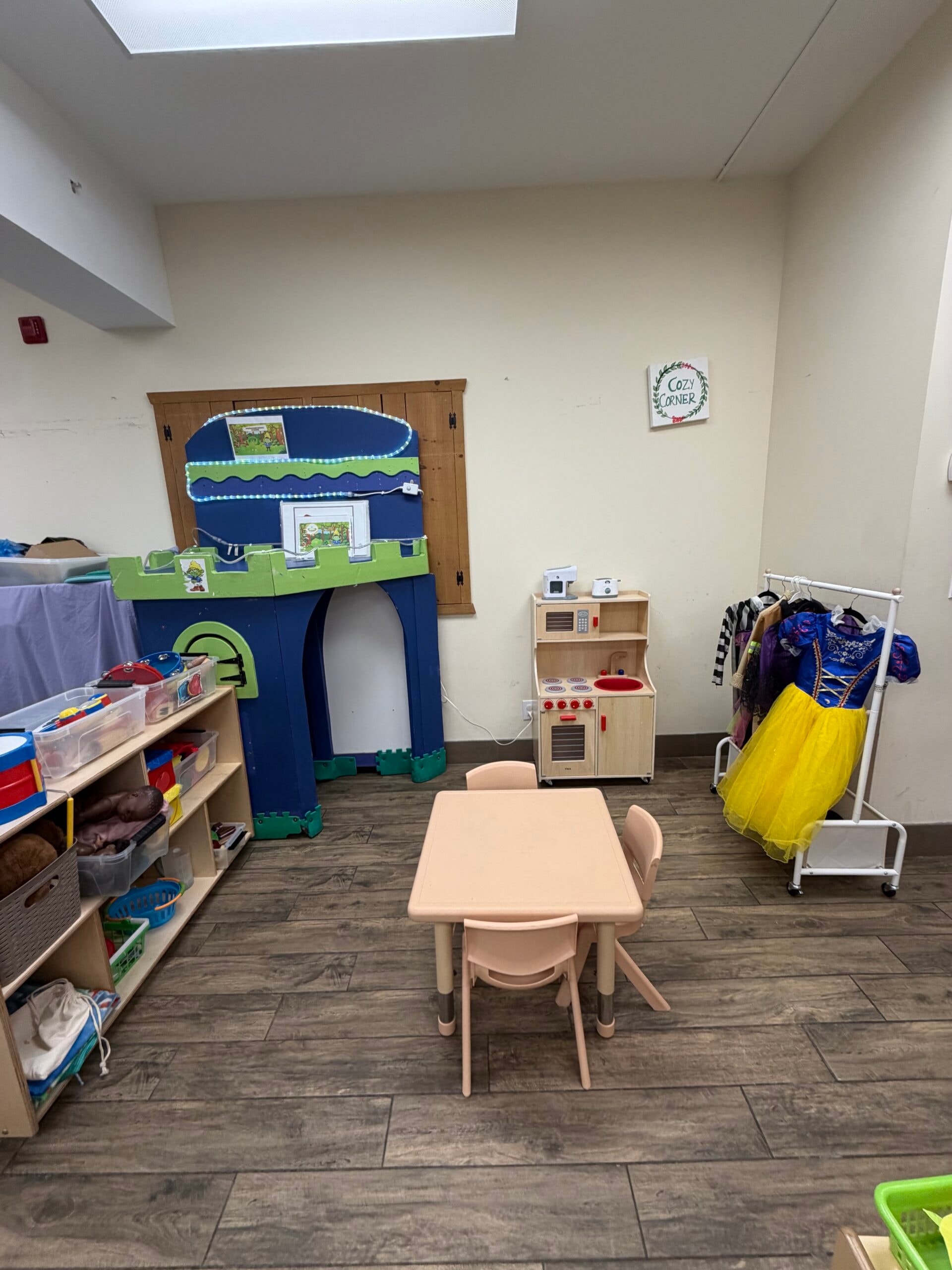 Preschool dramatic play area with castle, toy kitchen, and alphabet rug