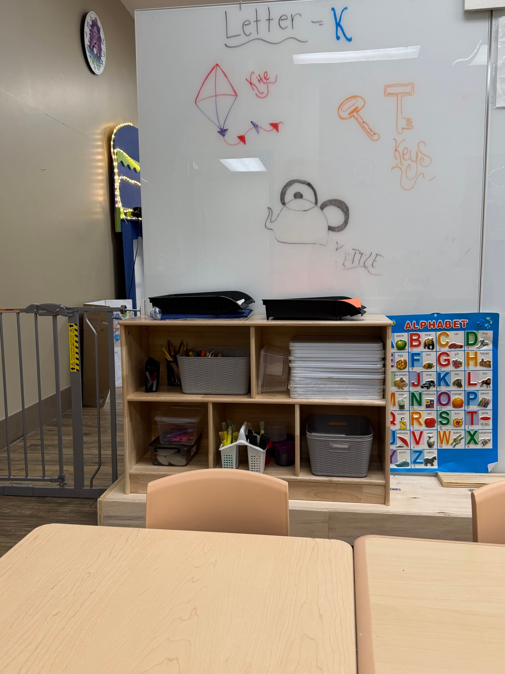 Preschool whiteboard with Letter K lesson, supply shelves, and alphabet poster
